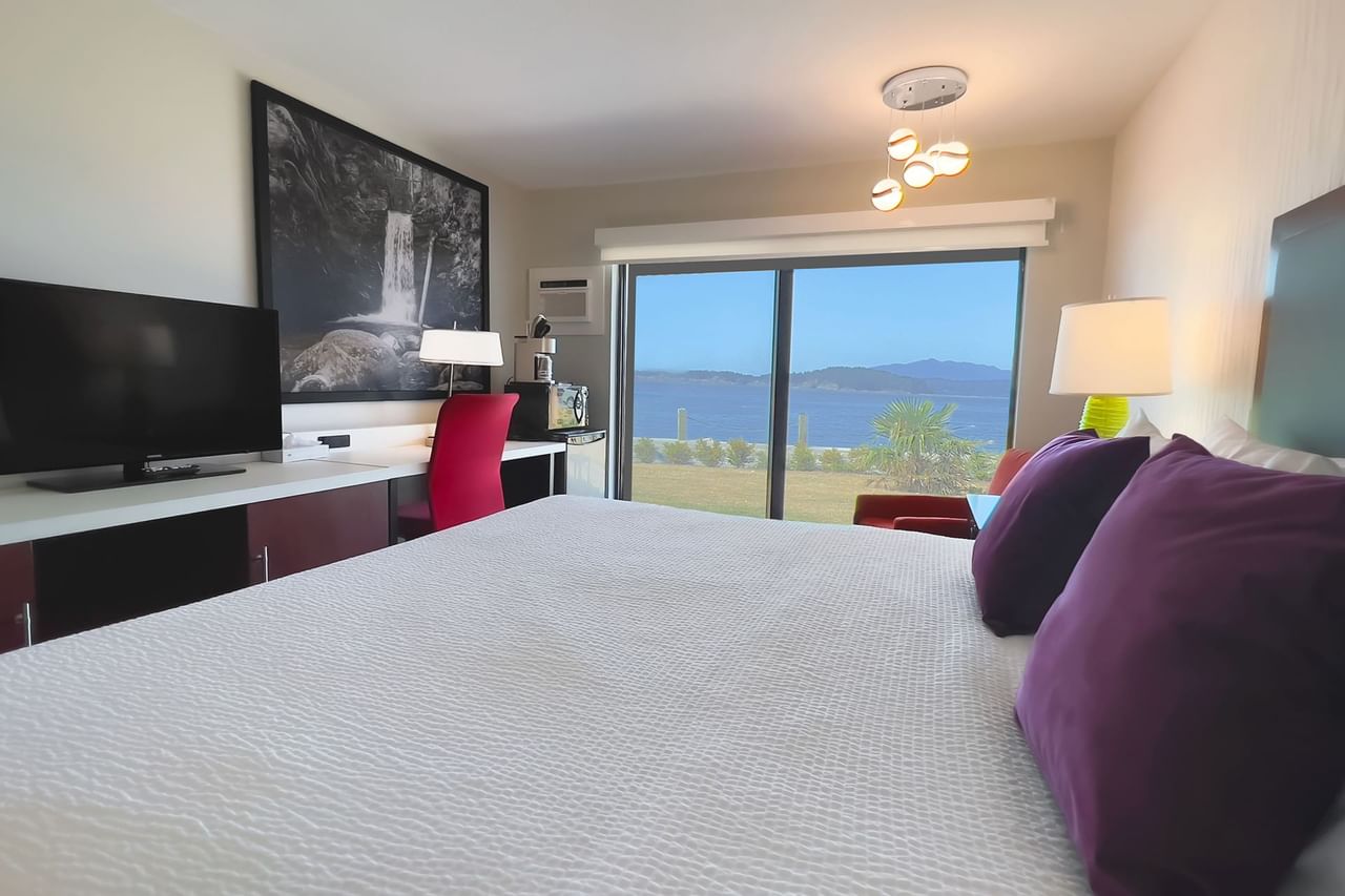 Guest room with two king beds, large desk, tv, patio doors, chair