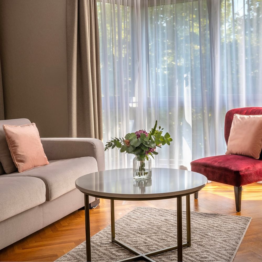 Salon confortable avec canapé, fauteuil et table au Warwick Reine Astrid.