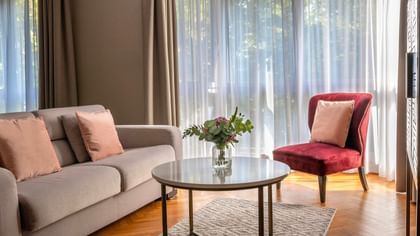 Salon confortable avec canapé, fauteuil et table au Warwick Reine Astrid.