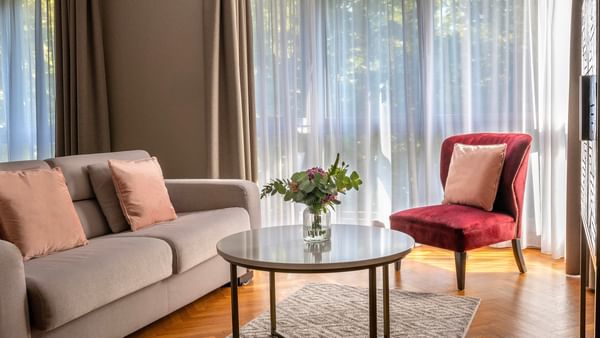 Salon confortable avec canapé, fauteuil et table au Warwick Reine Astrid.