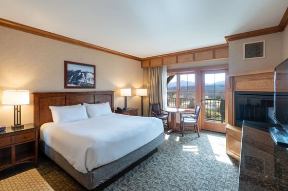 Bedroom at Lake Placid Club Grandview features a king-size bed and French doors leading to a balcony with mountain views