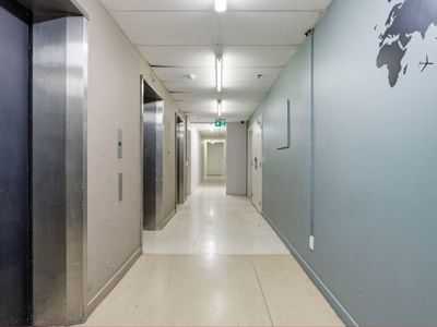 Elevator corridor with light blue walls and world map at UniLodge Stafford House.
