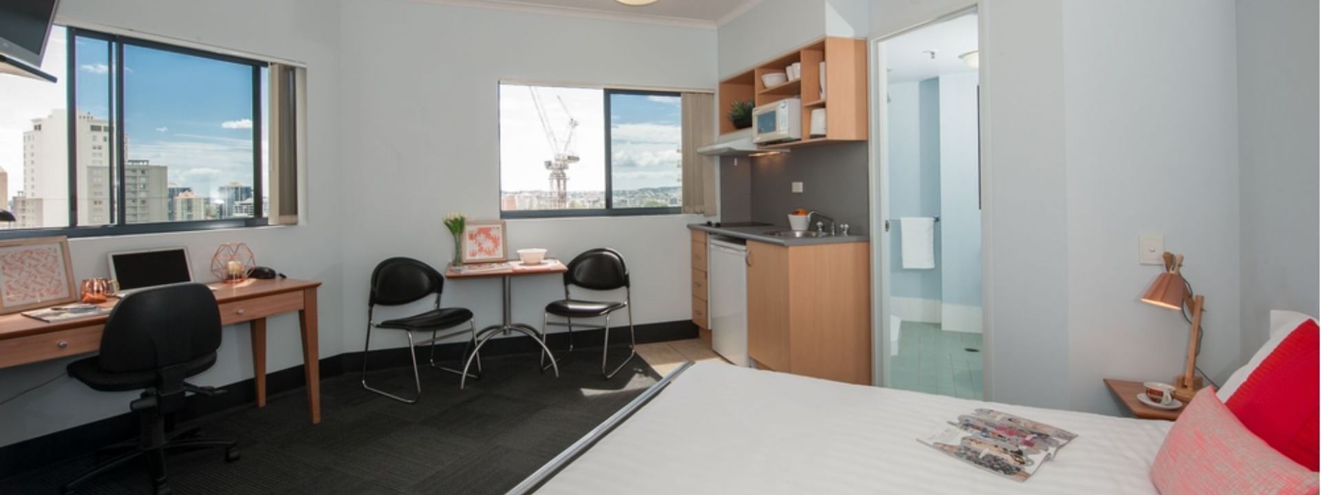 Studio Corner Deluxe with bed, desk, kitchenette, and city views at UniLodge on Margaret in Brisbane City.
