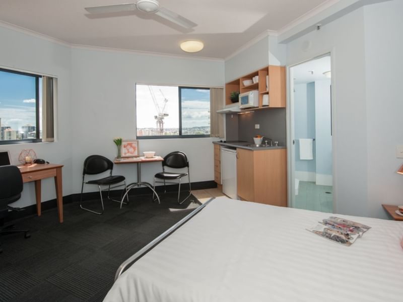 Studio Corner Deluxe with bed, desk, kitchenette, and city views at UniLodge on Margaret in Brisbane City.