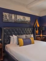 Bed with side tables and a couch in the Randolph Suite at Warwick New York