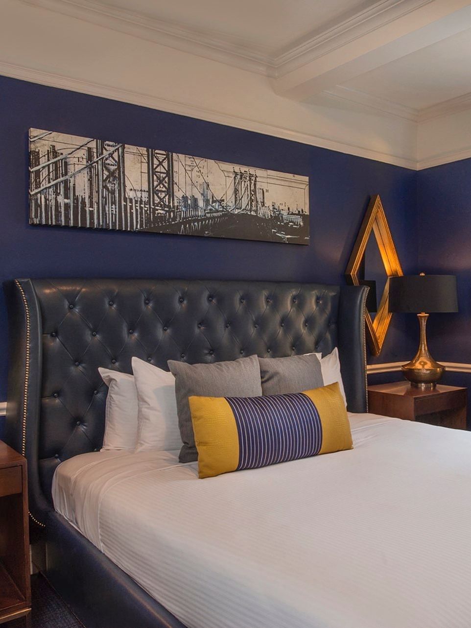 Bed with side tables and a couch in the Randolph Suite at Warwick New York