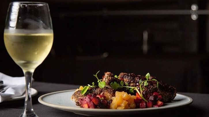 OSSO Steak & Ribs dish with glass of wine