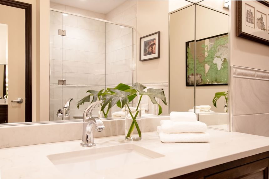 Bathroom vanity with mirror & towels in King Premiere room at Retro Suites Hotel