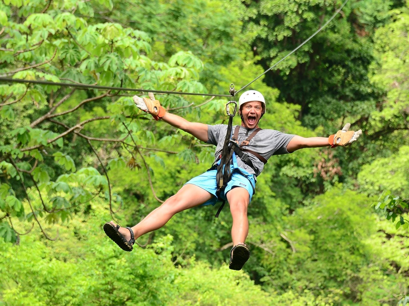 Man zip-lining through the forest near Jungle Vista Boutique Hotel