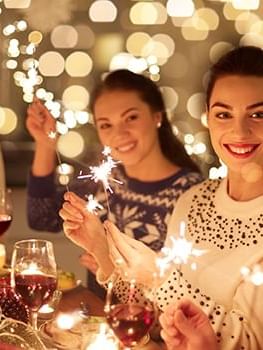 Guests holding sparklers by a dinner table under glowing bokeh lights at Warwick Grand Place Brussels