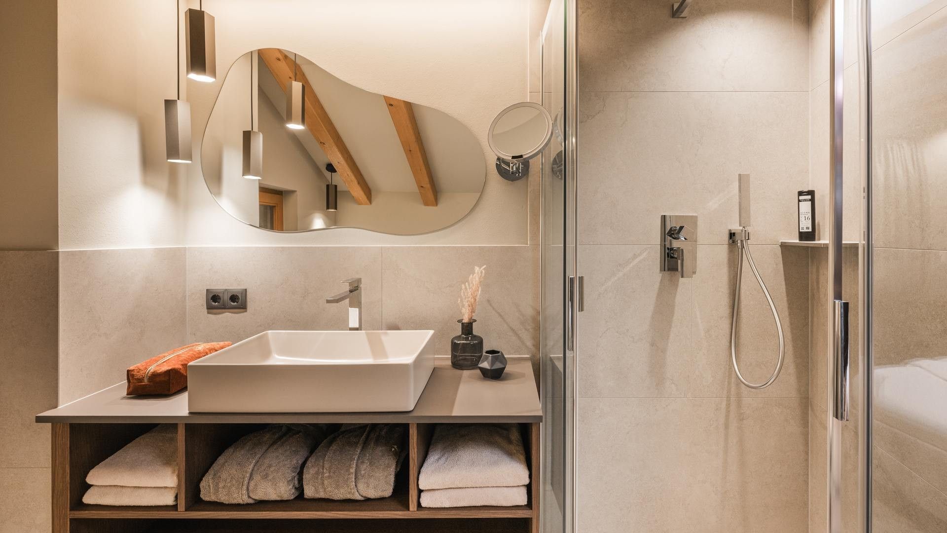 Bagno elegante con doccia e lavandino in marmo al Falkensteiner Hotel Antholz.