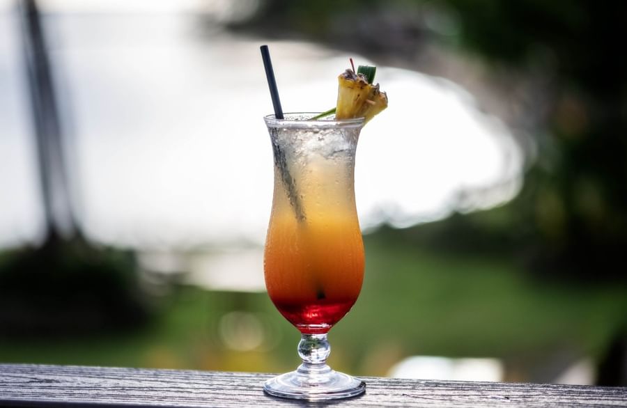 Chilled tropical cocktail by a wooden ledge at The Naviti Resort - Fiji
