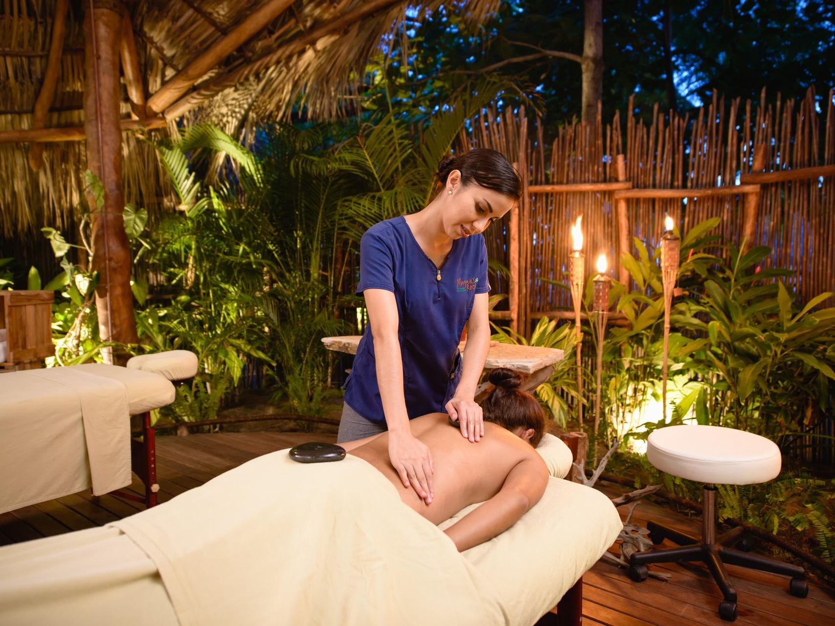 Therapist giving a hot stone massage to a guest in Paslama Spa, Spa San Juan Del Sur at Morgan's Rock Reserve & Ecolodge