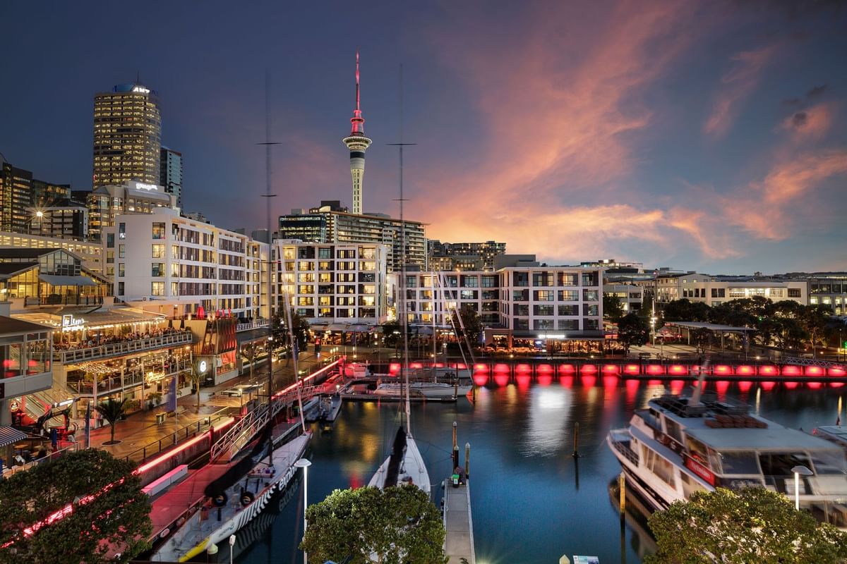 Stunning sunset view near The Sebel Auckland Viaduct Harbour with a marina, city lights, and a colorful sky