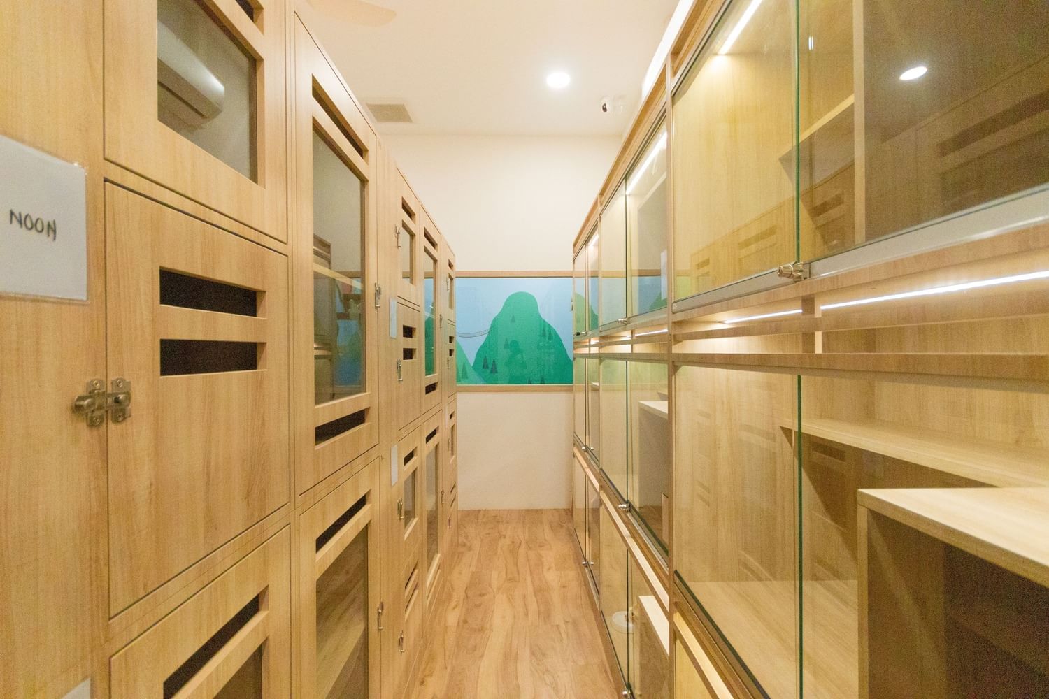 A long hallway featuring wooden cabinets with glass doors at Sunway Hotel Big Box
