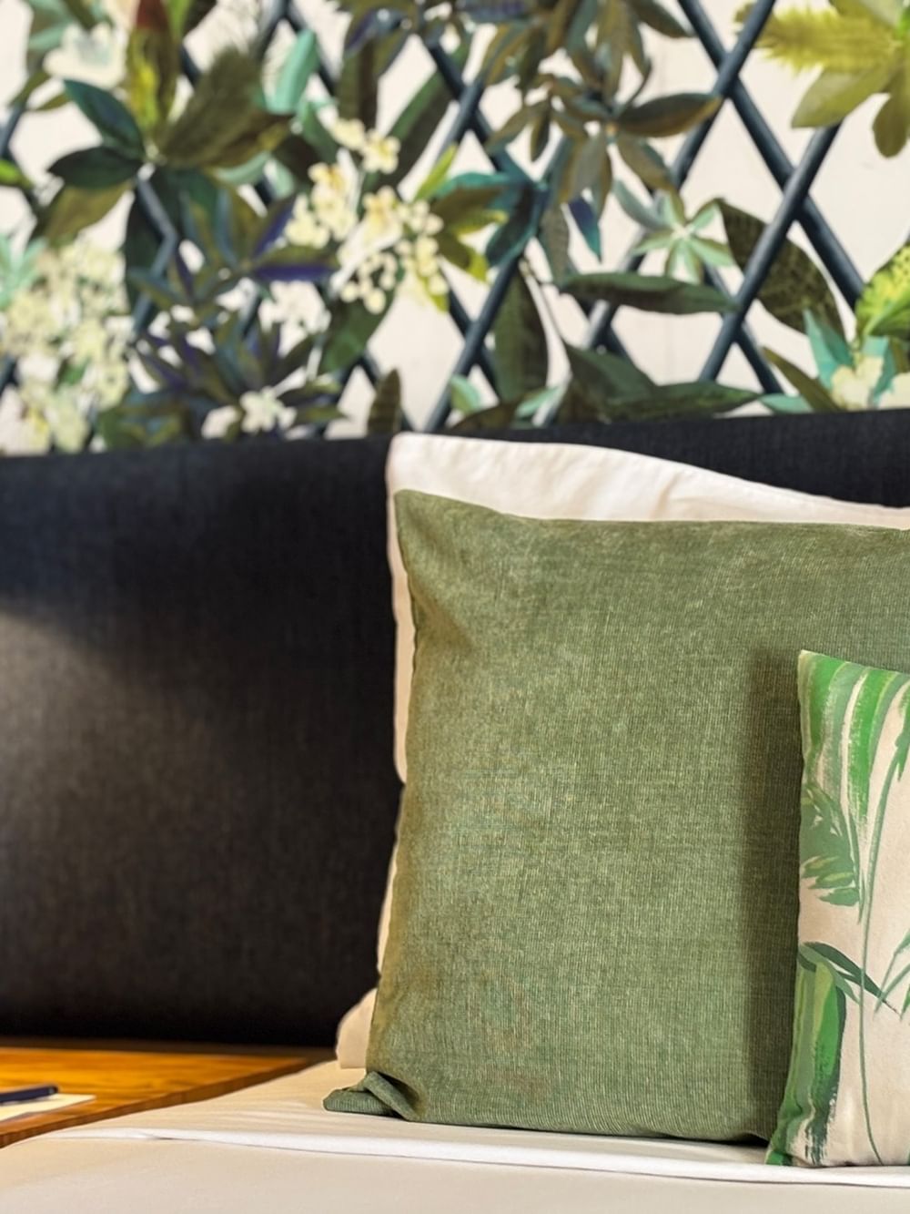 Lagoon Superior Room bed with green pillows and a nightstand lamp at Warwick Le Lagon - Vanuatu, Efate.
