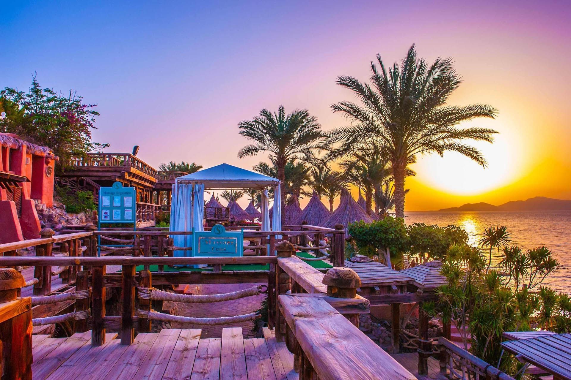 Sunset at Pickalbatros Golf Beach Resort in Beach Sharm El Sheikh, with palm trees and a gazebo overlooking the serene sea