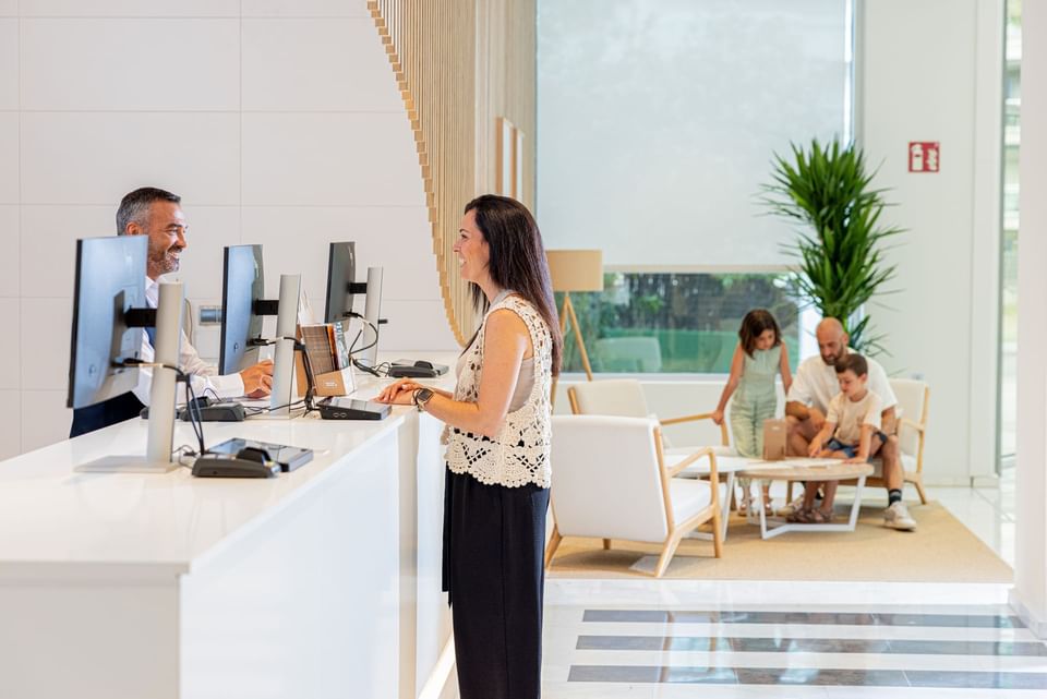 A woman having a conversation with receptionist at Hotel Piramide Salou