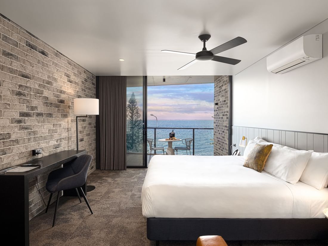 ocean view room with king bed and desk with floor lamp