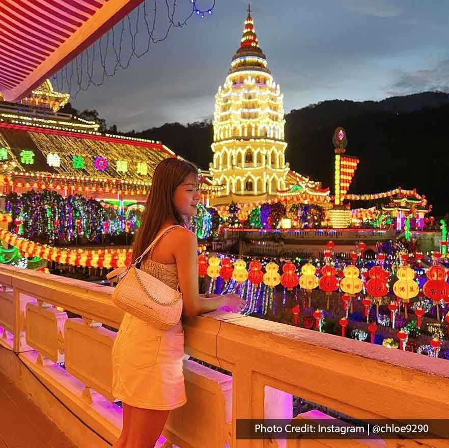A lady was taking a picture inside the Kek Lok Si at night - Lexis Suites Penang
