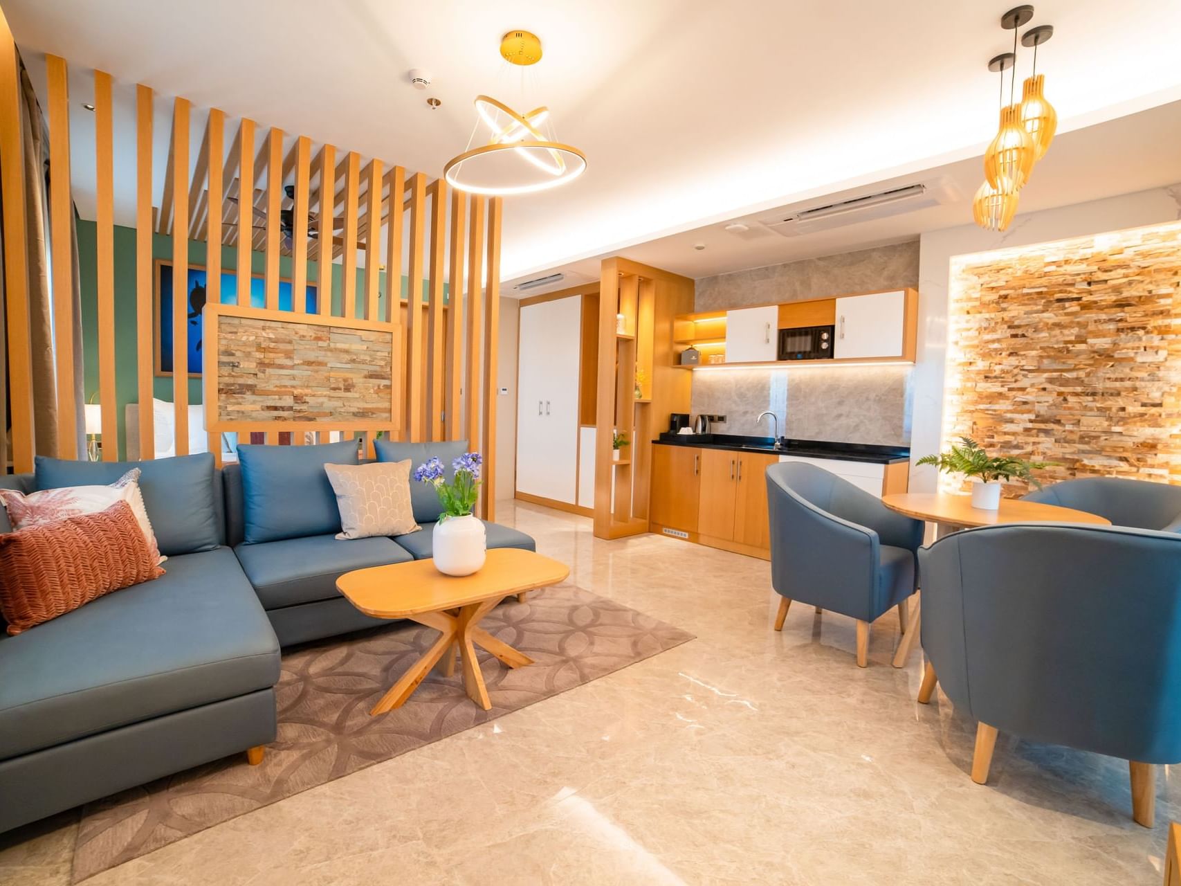 Modern living space with light wood accents, a kitchen area, and dining table in Villa Suite at Golden Rock Resort