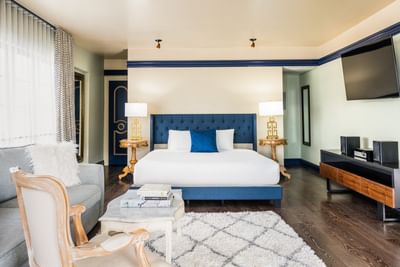 Modern room at Riviera Hotel South Beach with a blue tufted headboard and sleek minimalist furnishings