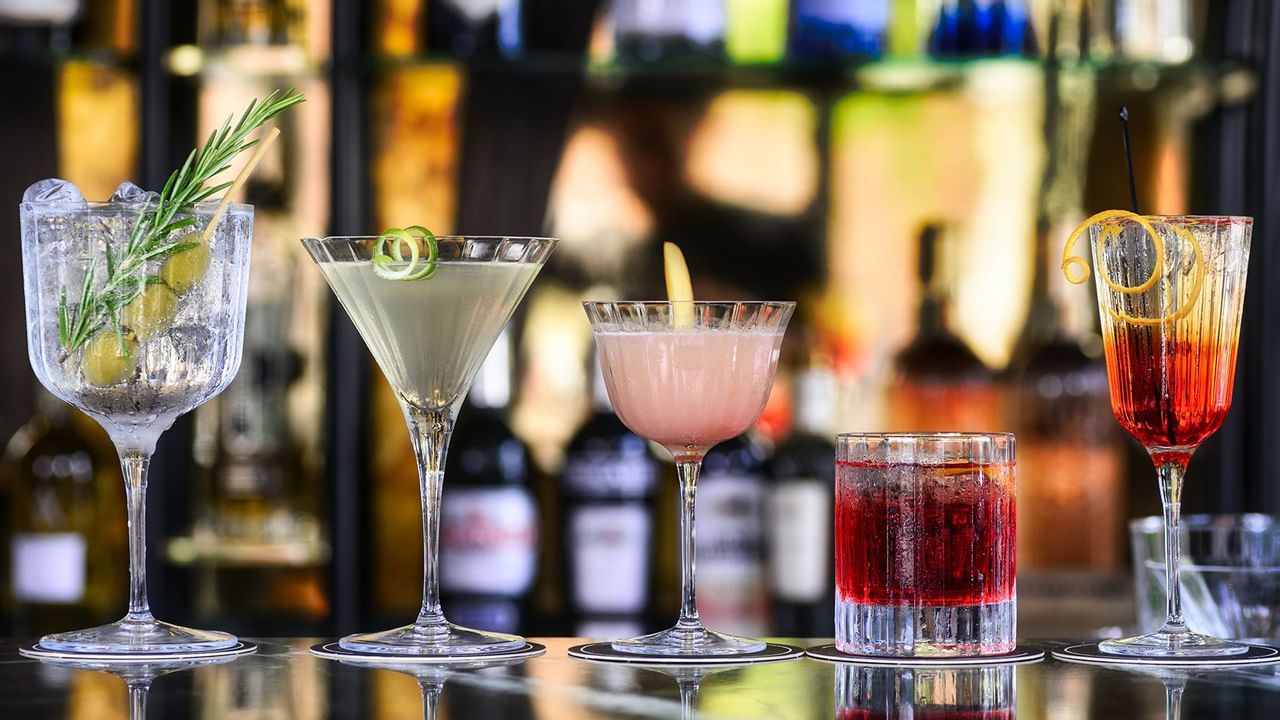 selection of craft cocktails lined up on a bar