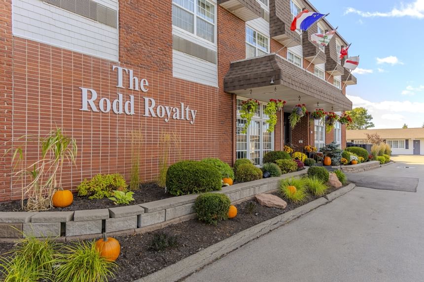 Brick exterior entrance and sign with hanging flower baskets and decorative pumpkins at The Rodd Royalty
