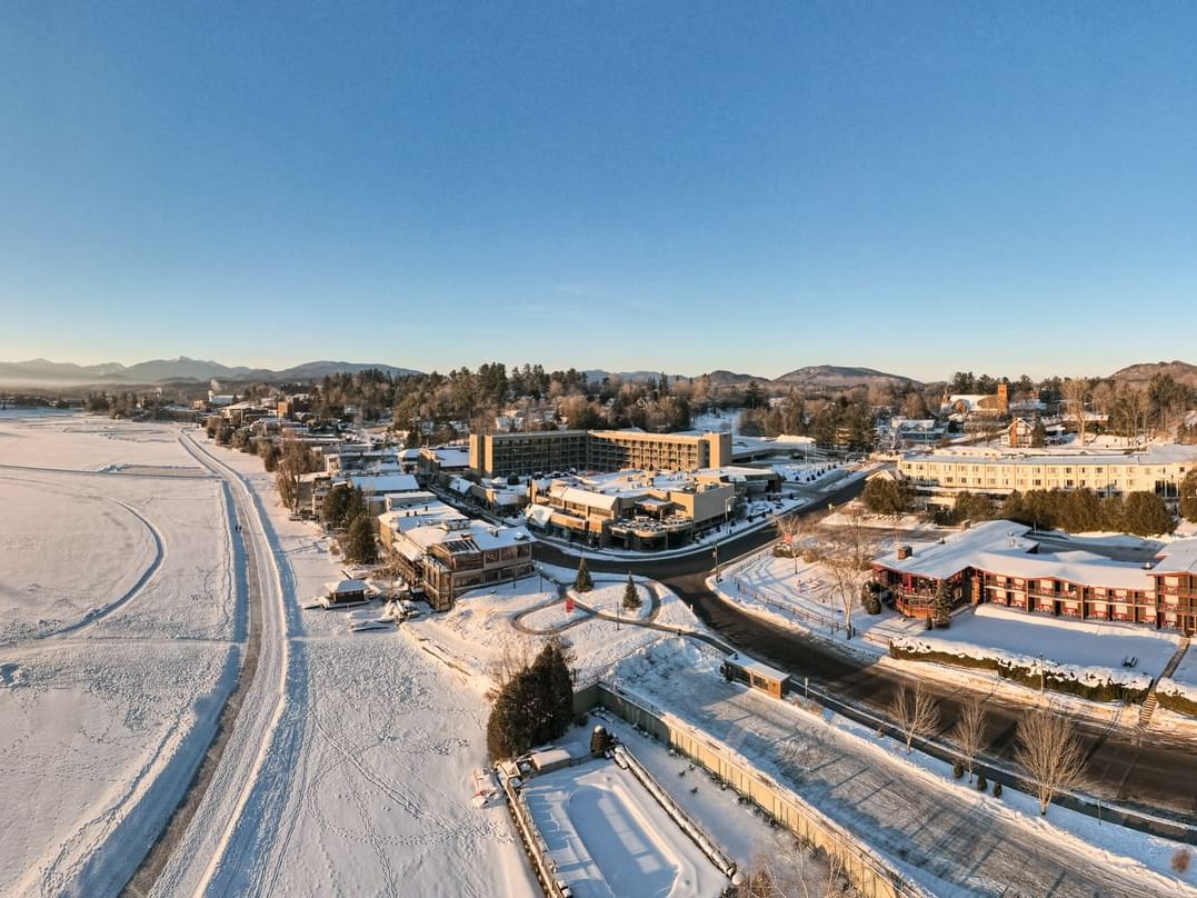 Aerial view of the snow-covered High Peaks Resort and the surrounding town with a frozen lake near the mountains