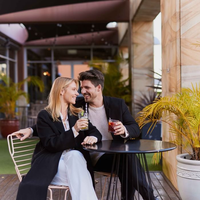 Couple enjoying sunset drinks on ibis bar deck