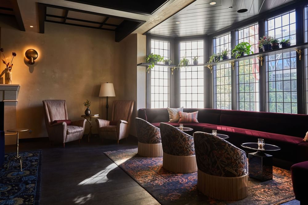 Lounge featuring comfortable seating, large windows, and elegant decor at El Prado Hotel