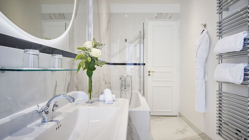Modern bathroom with mirrored sink and marble surface in Deluxe Belle-Époque Suite at Hôtel Westminster - Paris