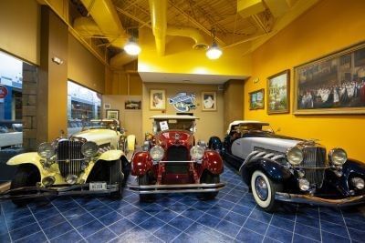 Classic vehicles in the Dusenberg Lounge area of the Orlando Auto Museum.