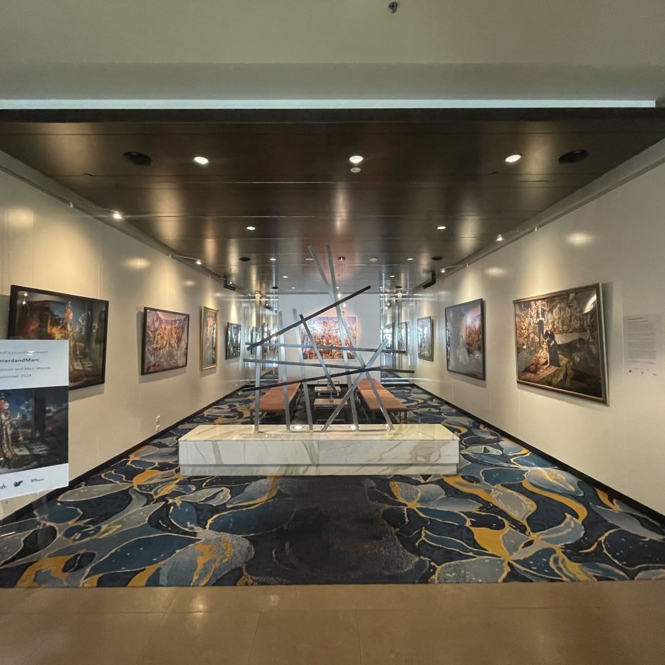 An art gallery featuring various paintings displayed elegantly on the walls near Sofitel Brisbane Central