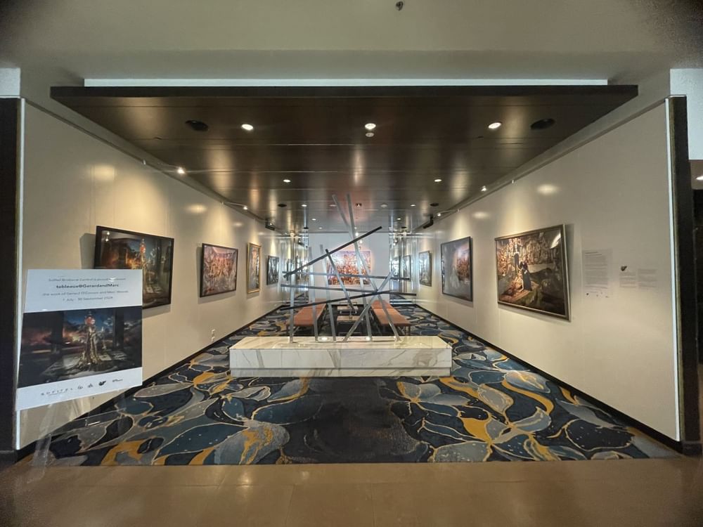 An art gallery featuring various paintings displayed elegantly on the walls near Sofitel Brisbane Central