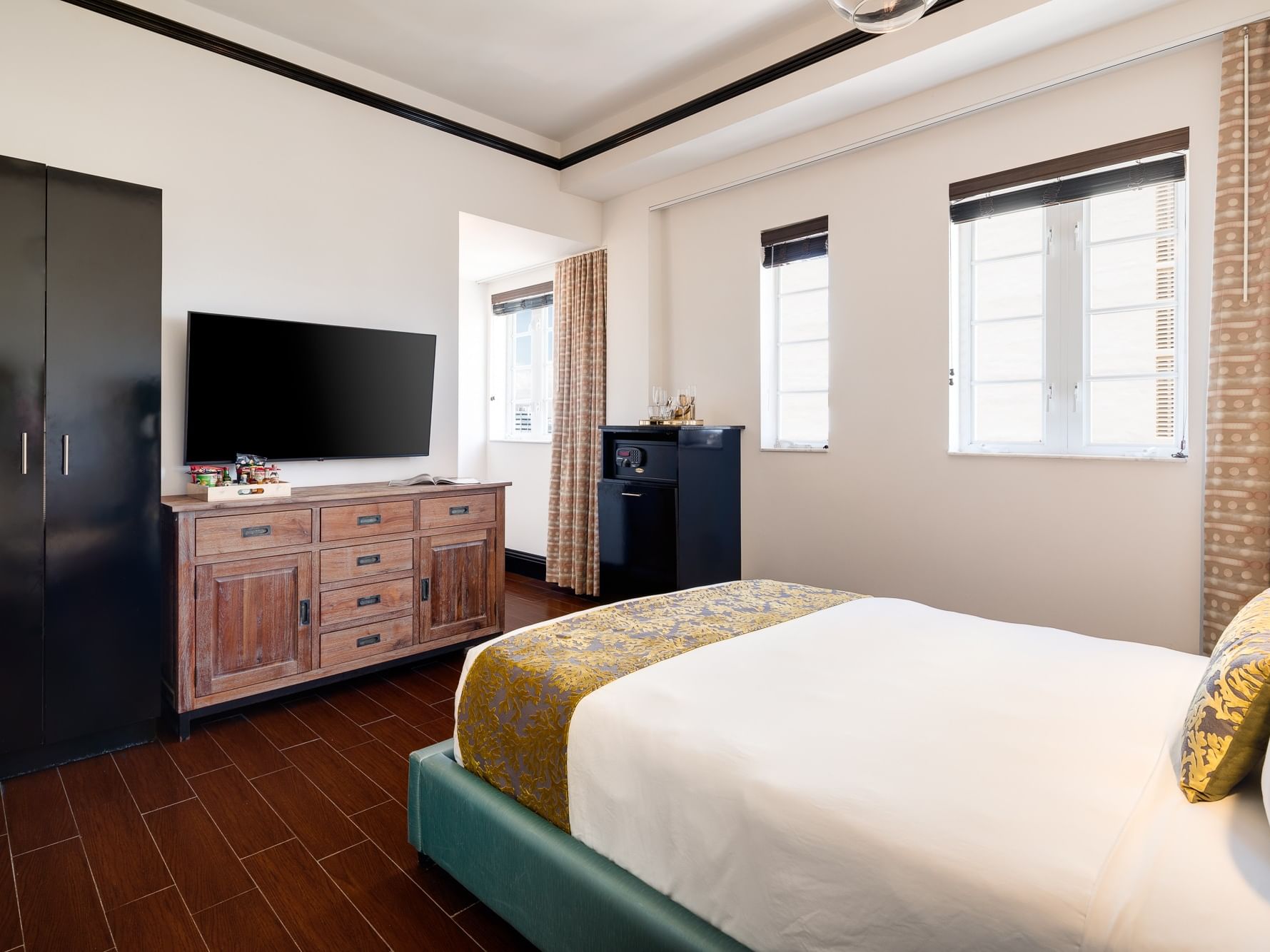 Accessible Classic Queen at Hotel Croydon Miami Beach with a bed, TV on dresser, armoire, mini fridge, and curtained windows