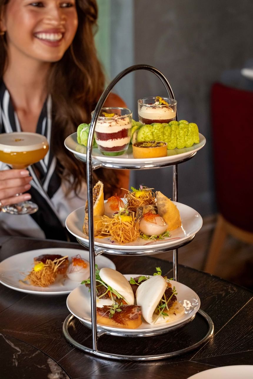 Elegant high tea setup at Grand Orient, featuring tiered trays of delicate pastries, desserts, and savory treats.