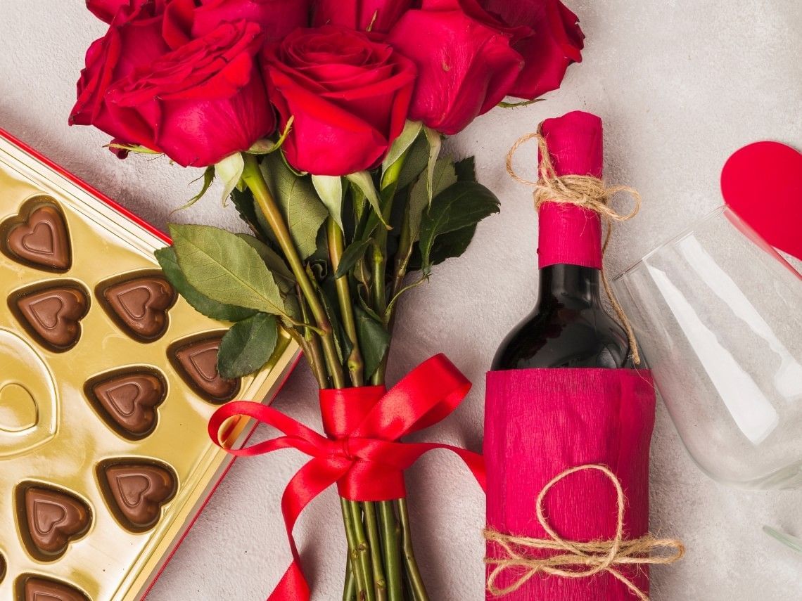 Wine, heart-shaped chocolates, and red roses arranged for Valentine’s Dinner at Pelangi