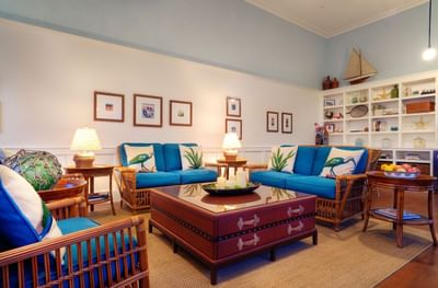 Living room with blue sofas and wooden furniture at Pavilion Hotel, one of the Catalina Island hotels on the beach