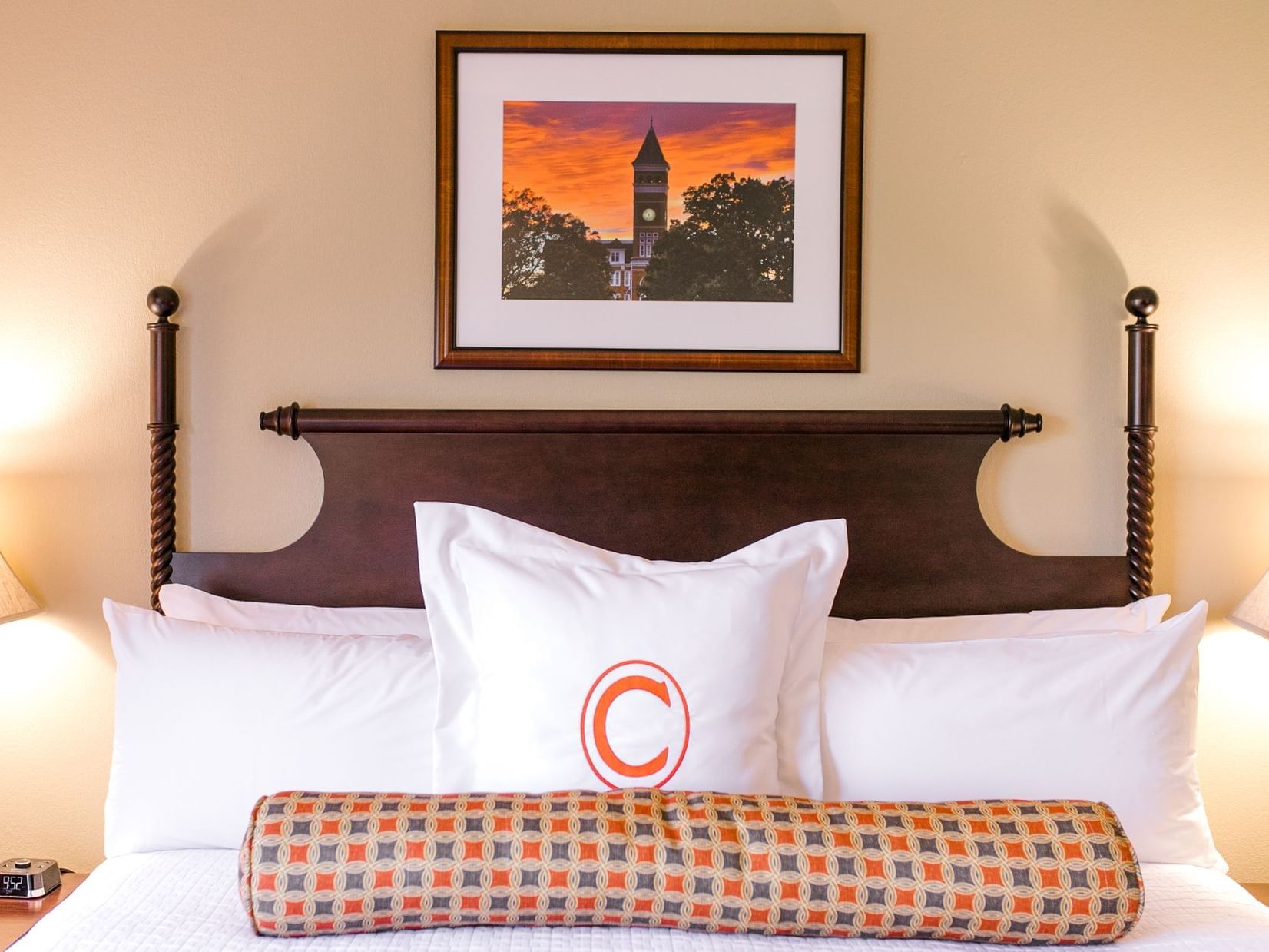 bed and pillow with the letter c and picture frame on the wall