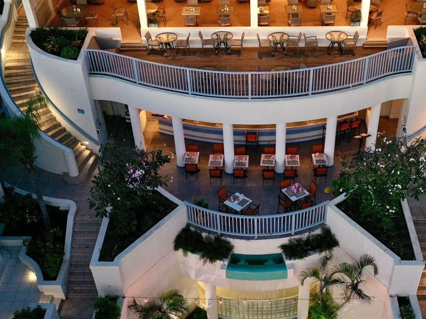 Elevated view of the Savannah Beach Hotel with dining areas, balconies, and lush greenery.