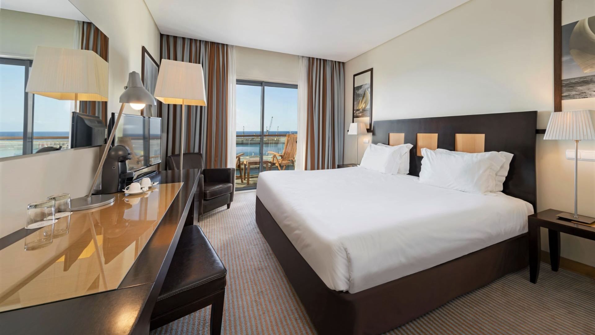 Large bed, work desk, lamps & balcony in Executive Ocean View Room at Hotel Marina Atlântico