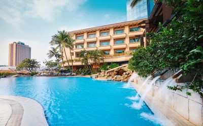Outdoor pool area with trees at Paradox Hotels