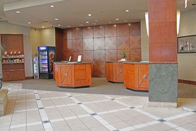 Hotel Topeka at City Center's welcoming front desk in the lobby set beside a grab-and-go store.