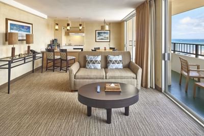 Spacious living area with cozy loungers by the balcony in One Bedroom Penthouse Suite at Waikiki Resort Hotel by Sono