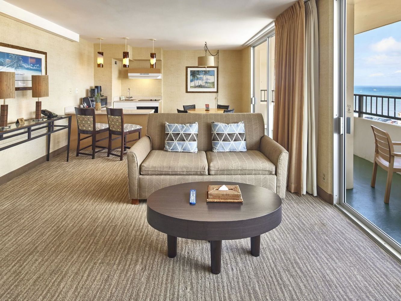 Spacious living area with cozy loungers by the balcony in One Bedroom Penthouse Suite at Waikiki Resort Hotel