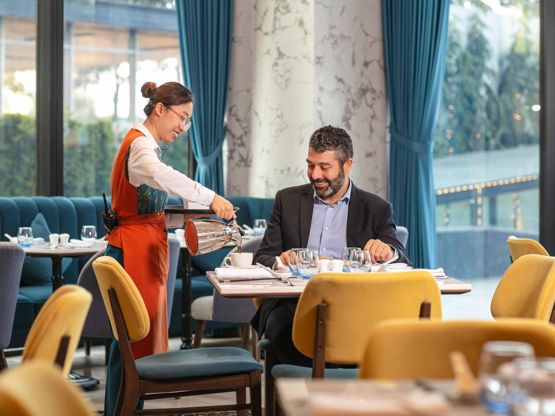 Staff member serving tea in Eastin Cafe at Eastin Hotels