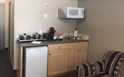 Kitchenette featuring a microwave, fridge, and sink in Vantage Room at Fort McMurray Hotels