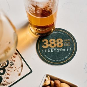 A beer glass with 388 Sports Bar logo is placed on the table at 388 Sports Bar