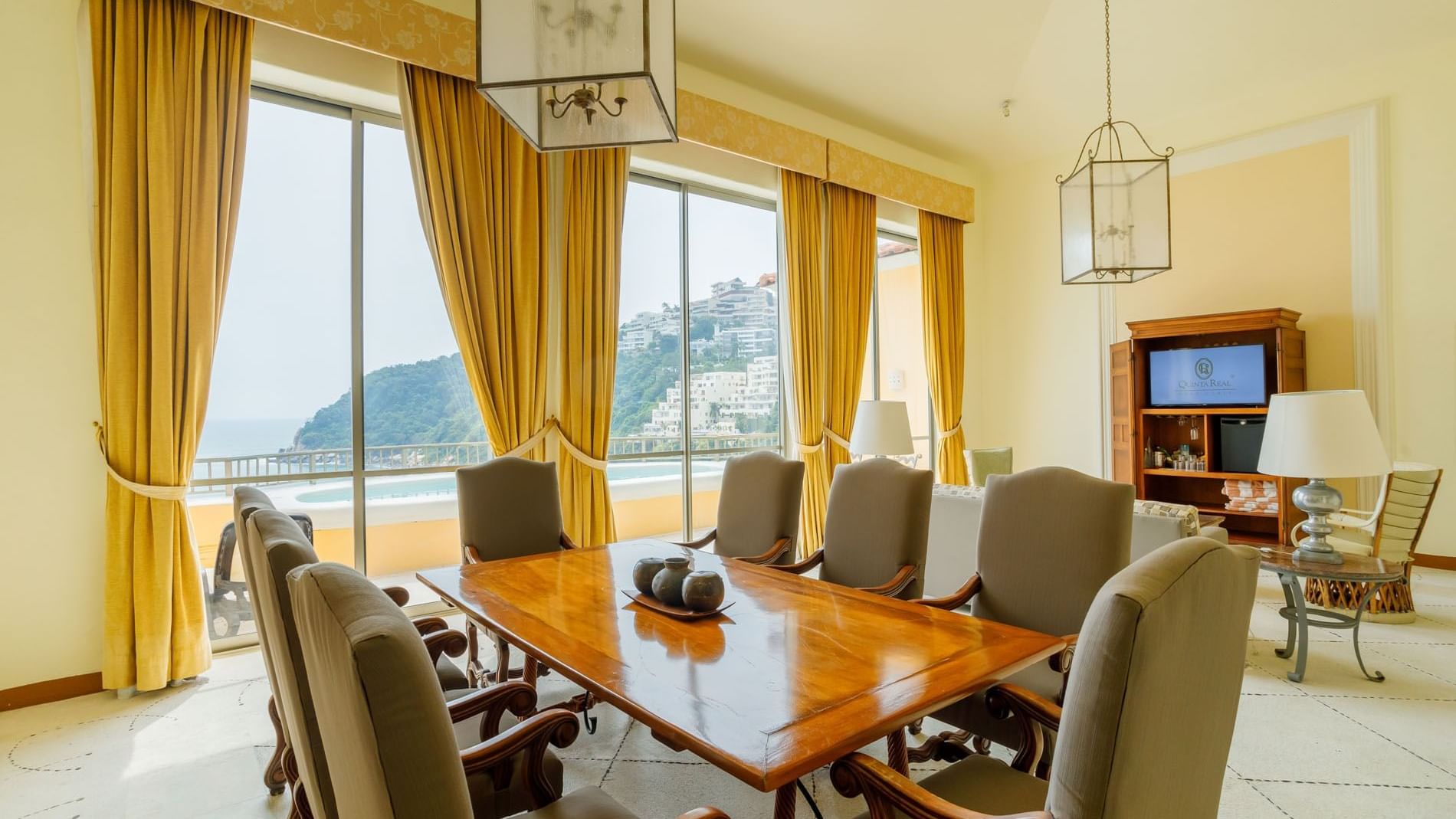 King Presidential Suite dining area featuring a large wooden table and stunning balcony views at Quinta Real Acapulco